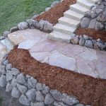 Boulder wall and flagstone steps with mulch