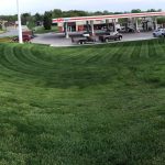 Striped lawn beside a gas station