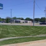 Mowed commercial lawn by a parking lot